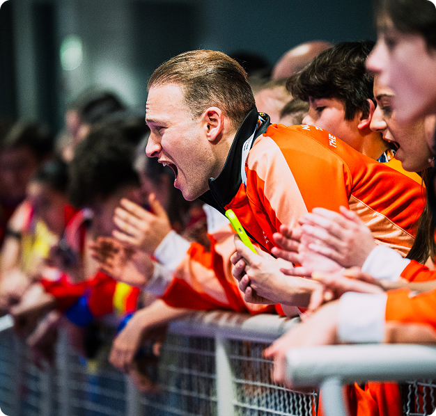 Dutch athlete cheering for their teammate from the sidelines